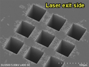 Electron micrograph of square holes machined in diamond, seen from the laser exit side
